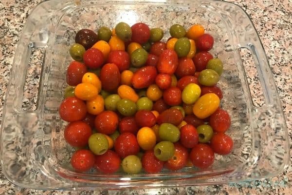 Grape Tomatoes and Olives seasoned in preparation for Baked Feta Pasta