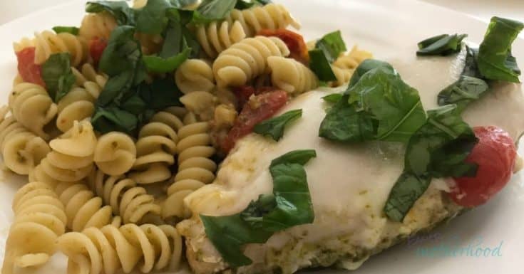 Photo of finished pesto pasta with chicken on a white plate