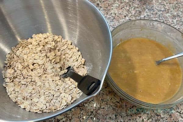 Two bowls, one with dry ingredients mixed, the other with the mixed wet ingredients 