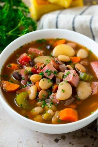 A white bowl filled with dump and go ham and bean soup with kitchen items in the background.