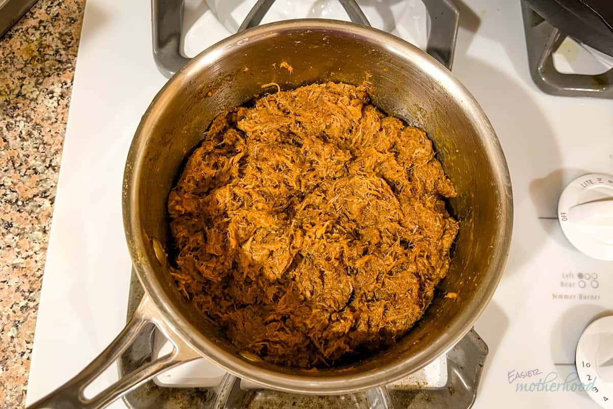 Saucepan on stove with reheated and seasoned pulled pork