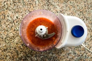 Strawberries and syrup in a food processor after blending