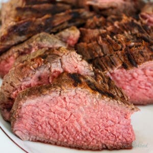 Sliced tri tip on white plate.