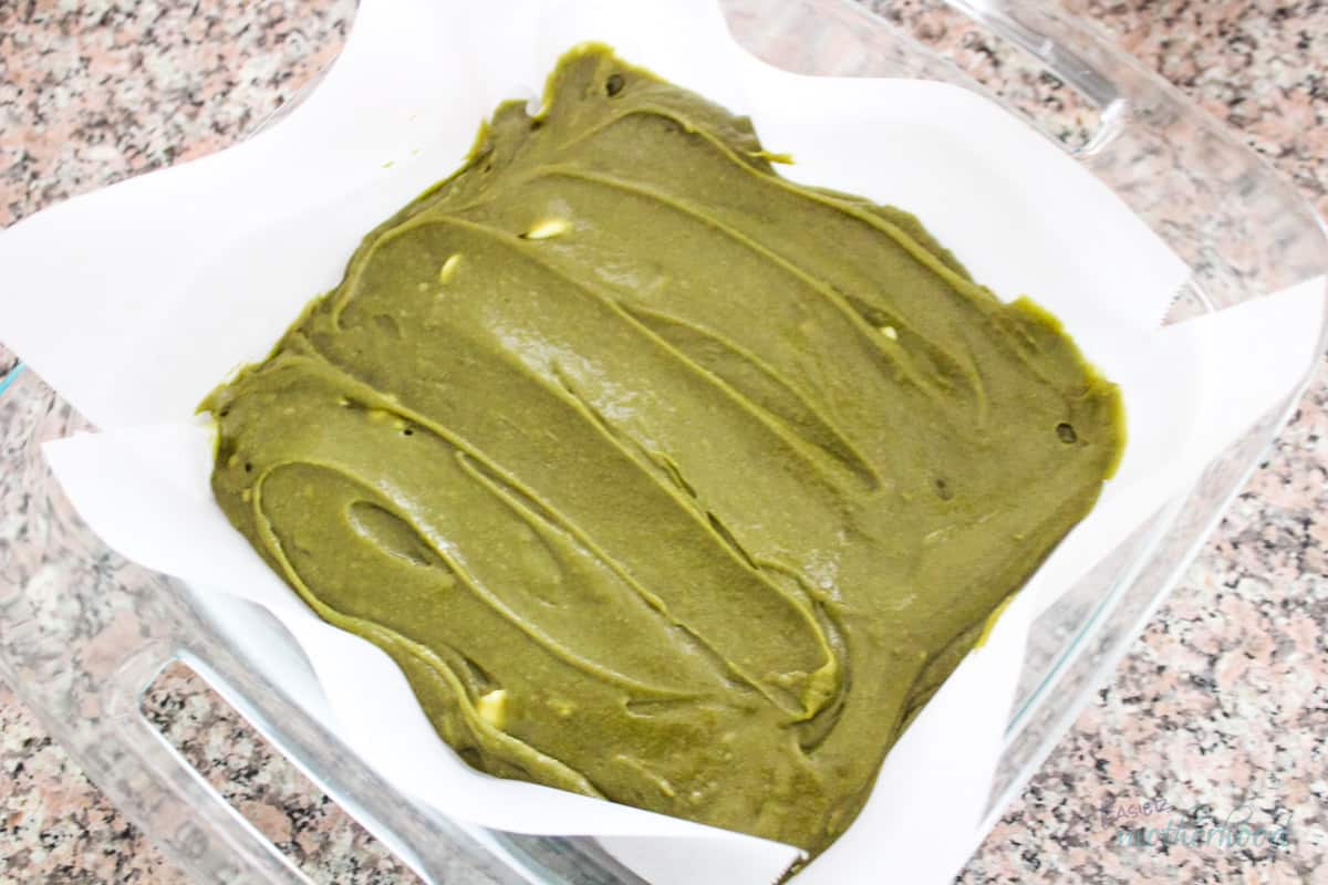 Prepared matcha brownie batter in parchment paper lined pan