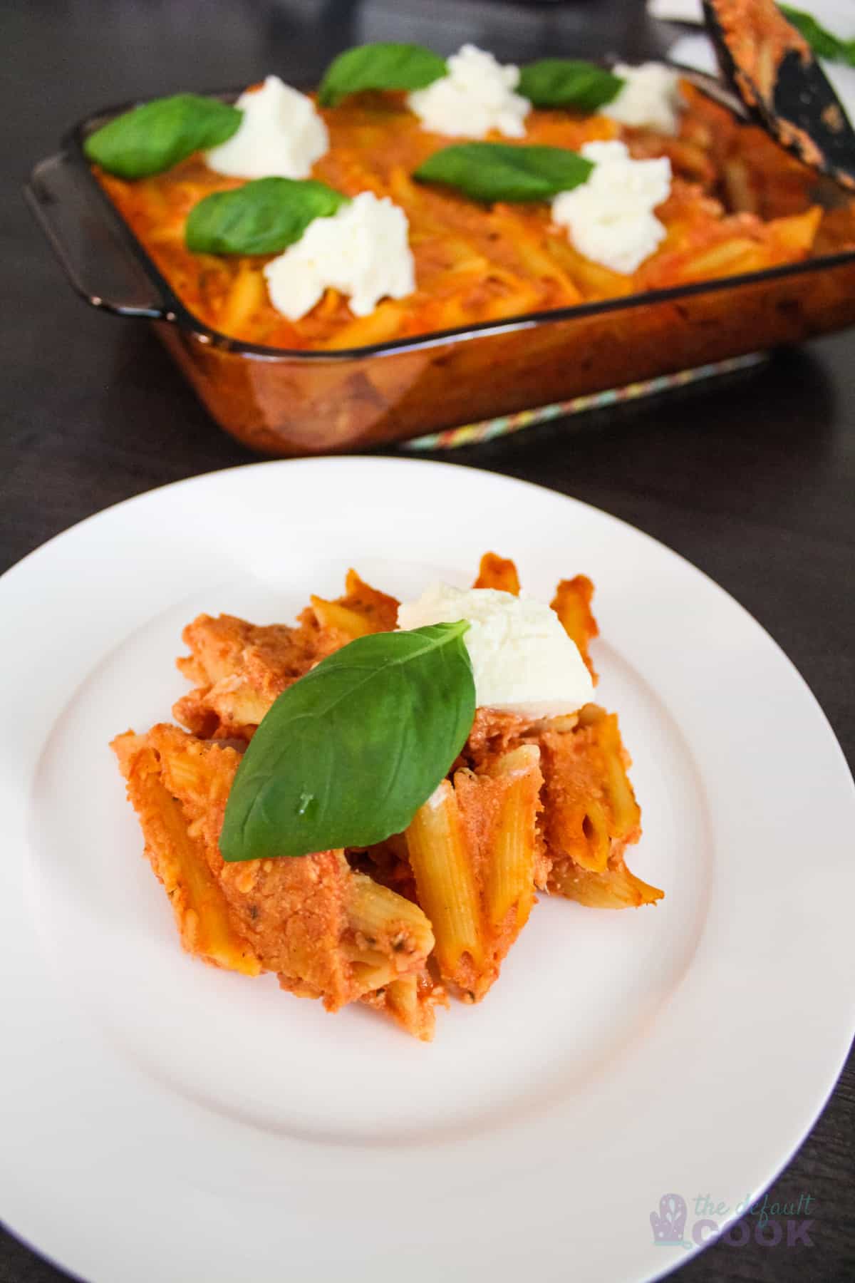 Plate of four-cheese pasta with the casserole dish behind it.