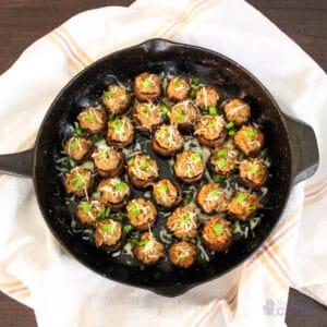 Skillet of stuffed mushrooms on a kitchen towel