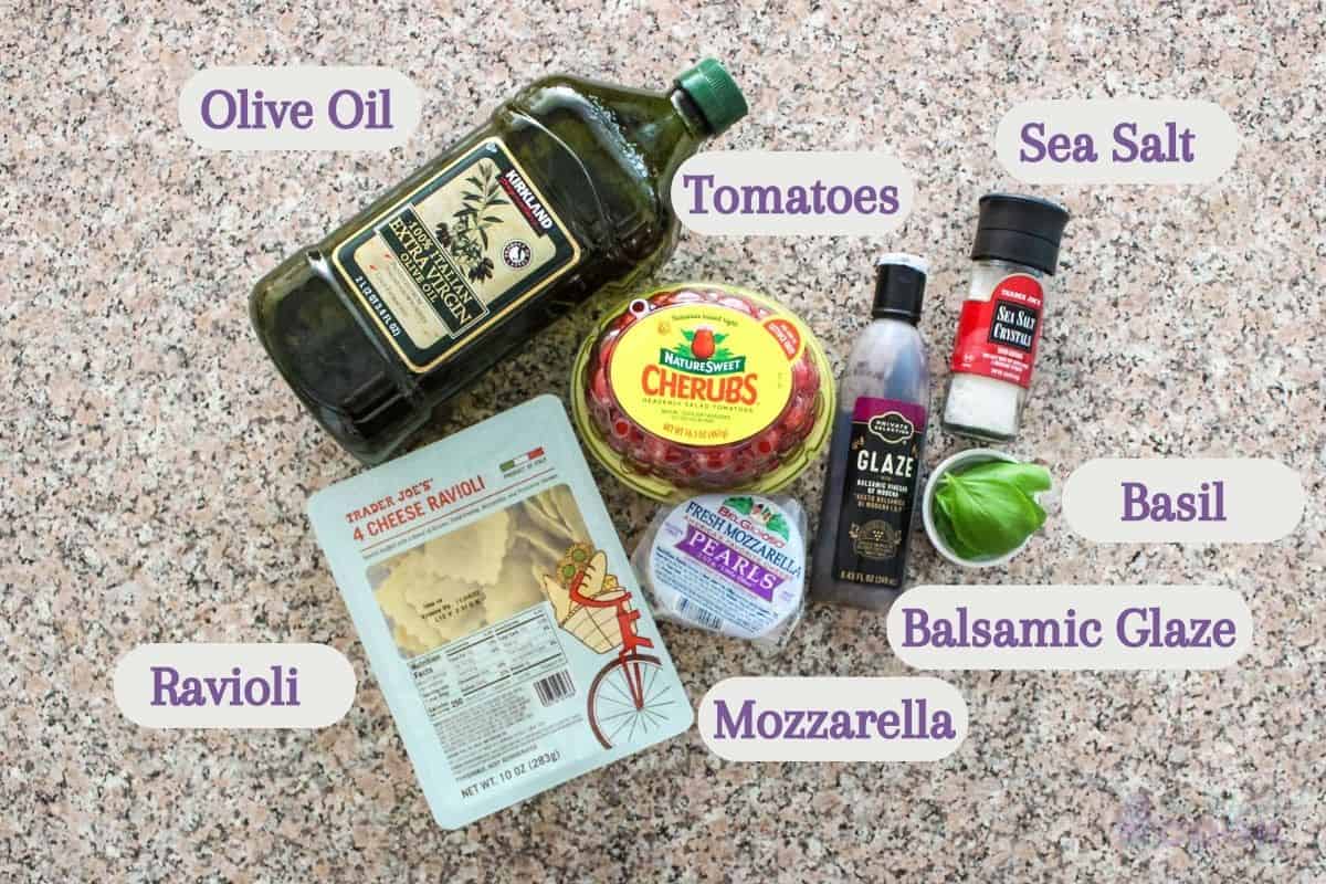 Labeled overhead shot of caprese ravioli ingredients on a kitchen counter.