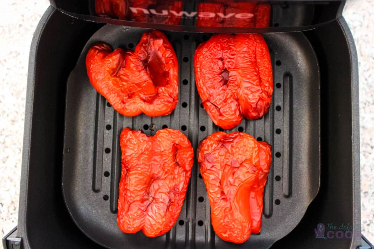 Air fryer with finished peppers inside.