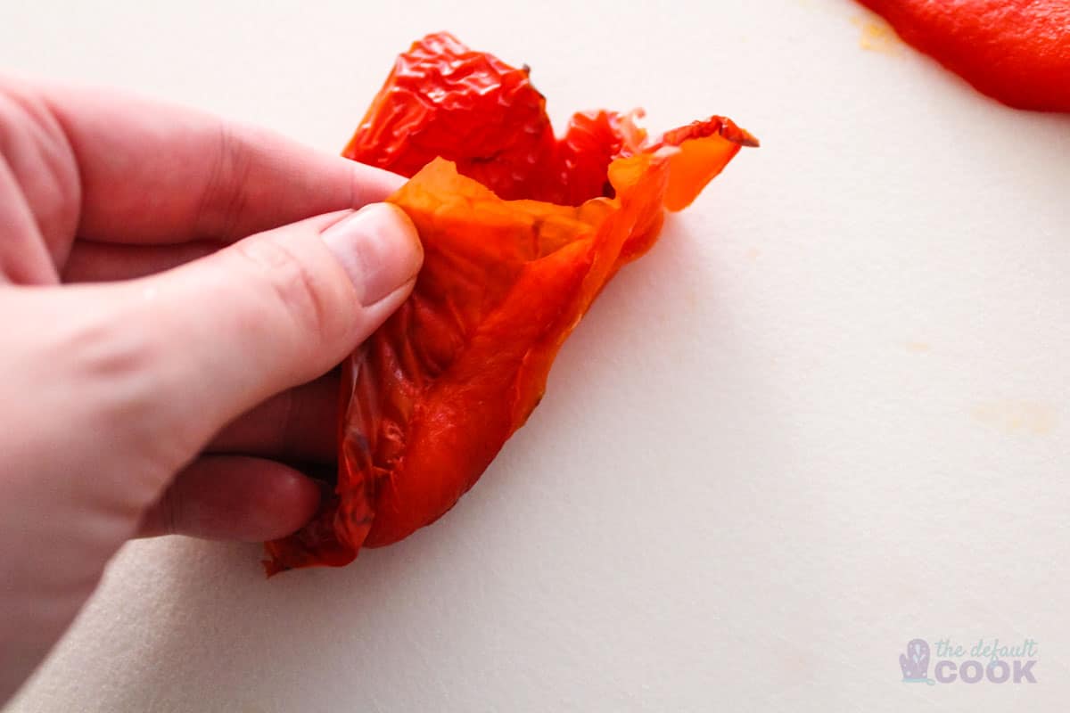 Peeling the skin away from the edges of the roasted red pepper.