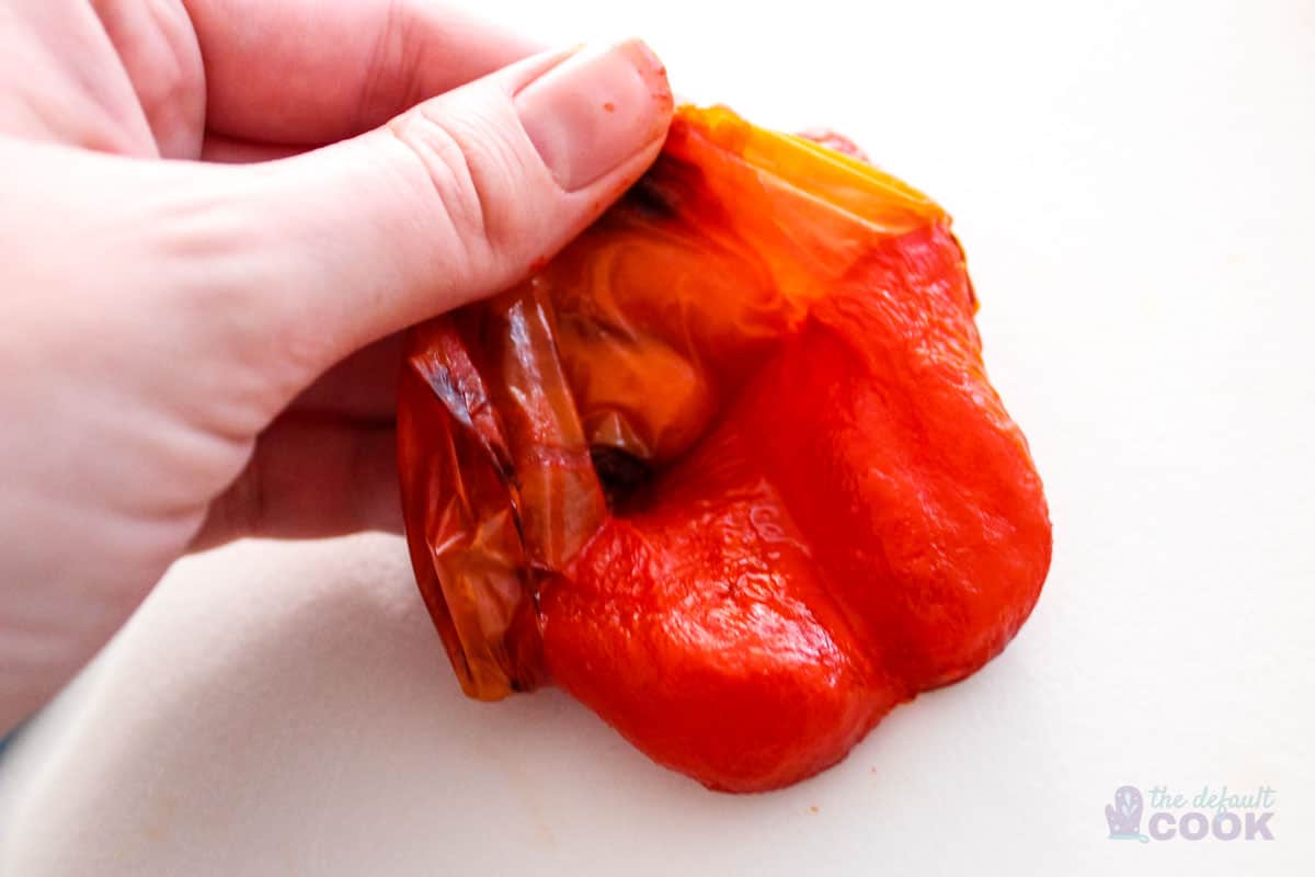 Peeling the skin off the red pepper in the middle.