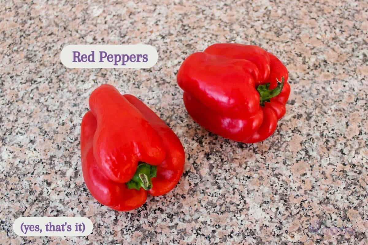 Two red peppers on a kitchen counter.