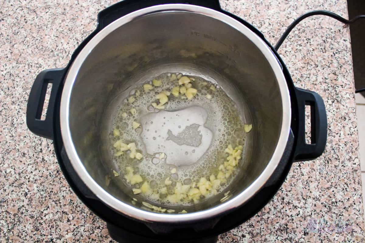 Garlic and butter cooking on saute mode in instant pot.