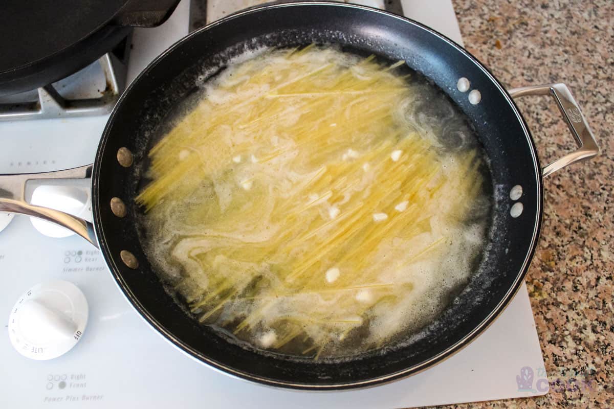 Water and lemon juice added to pan ready to cook the noodles.