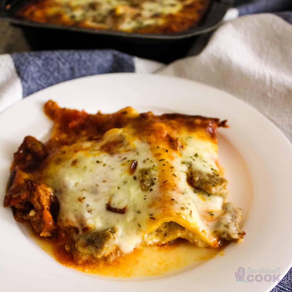 Serving of Costco Lasagna on a white plate with rest of tray in background.