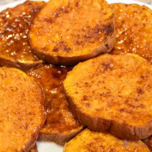 Photo of roasted sweet potato slices on a white plate.