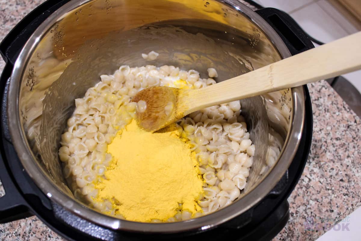 Cooked pasta with cheese powder, milk, and butter added but not stirred.