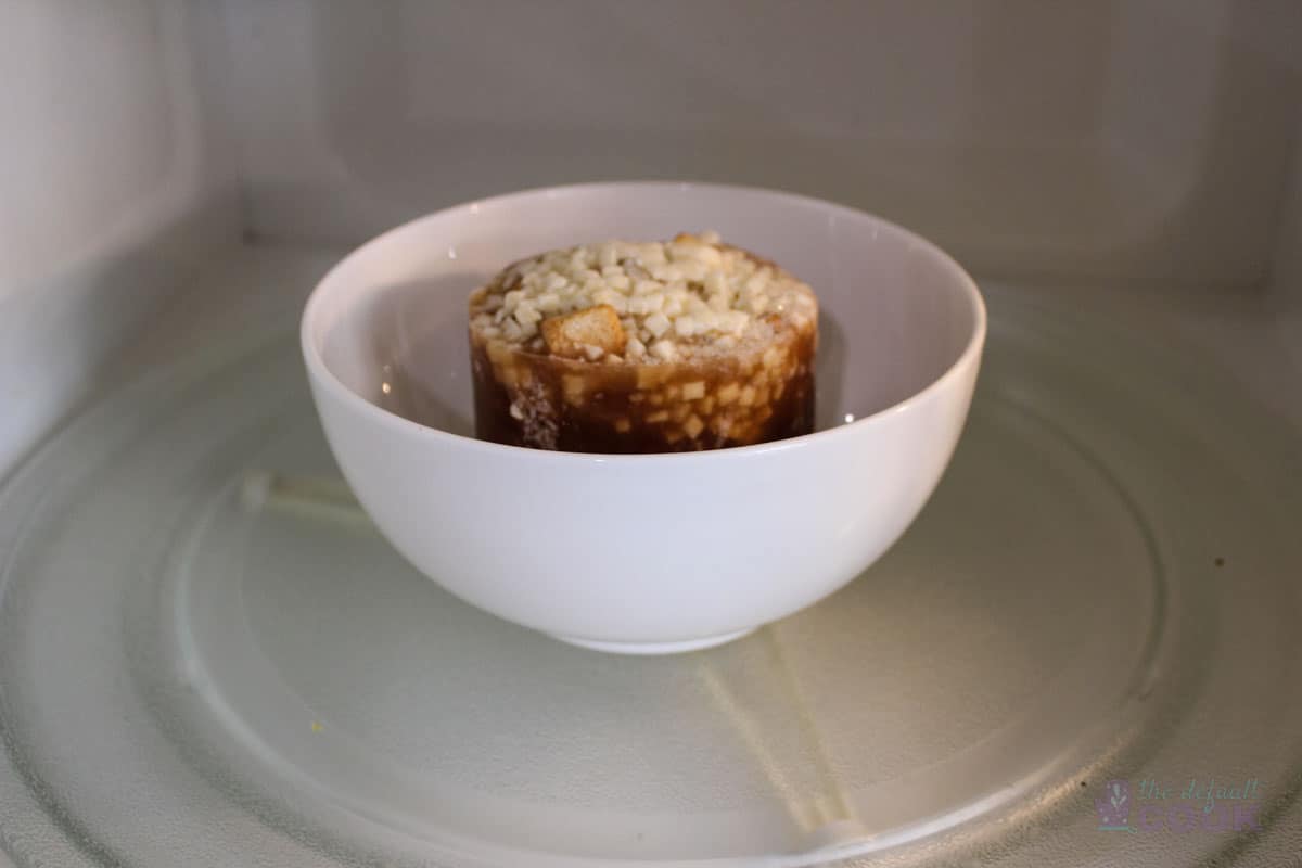 Frozen soup inside microwave ready to be heated.