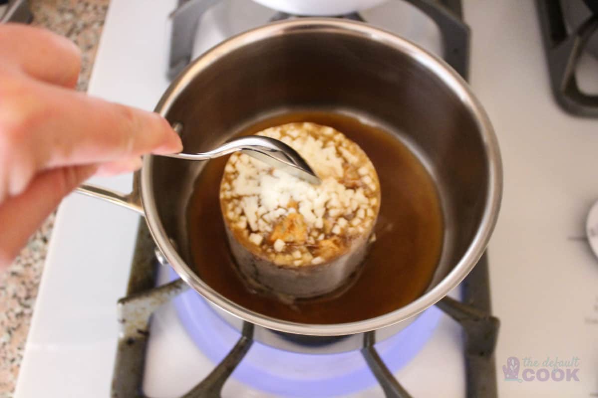 Frozen soup in sauce pan just starting to melt.