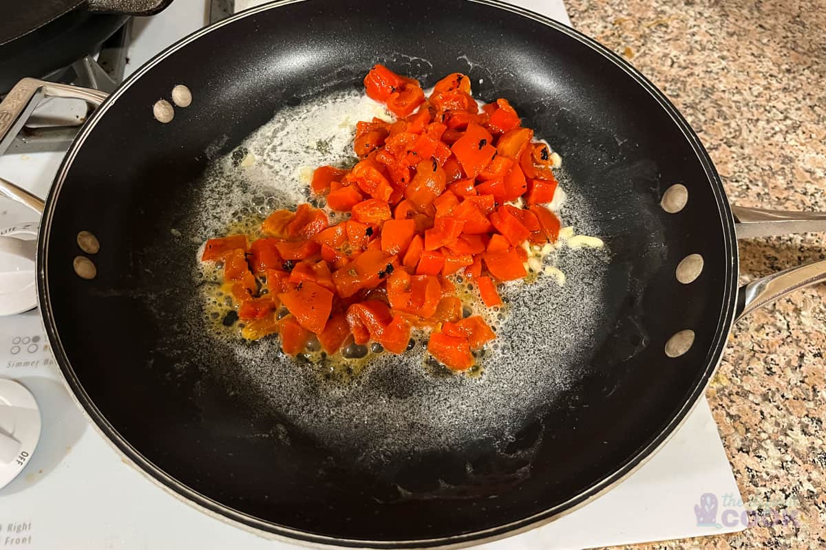 Skillet after adding red peppers to hot butter and garlic.