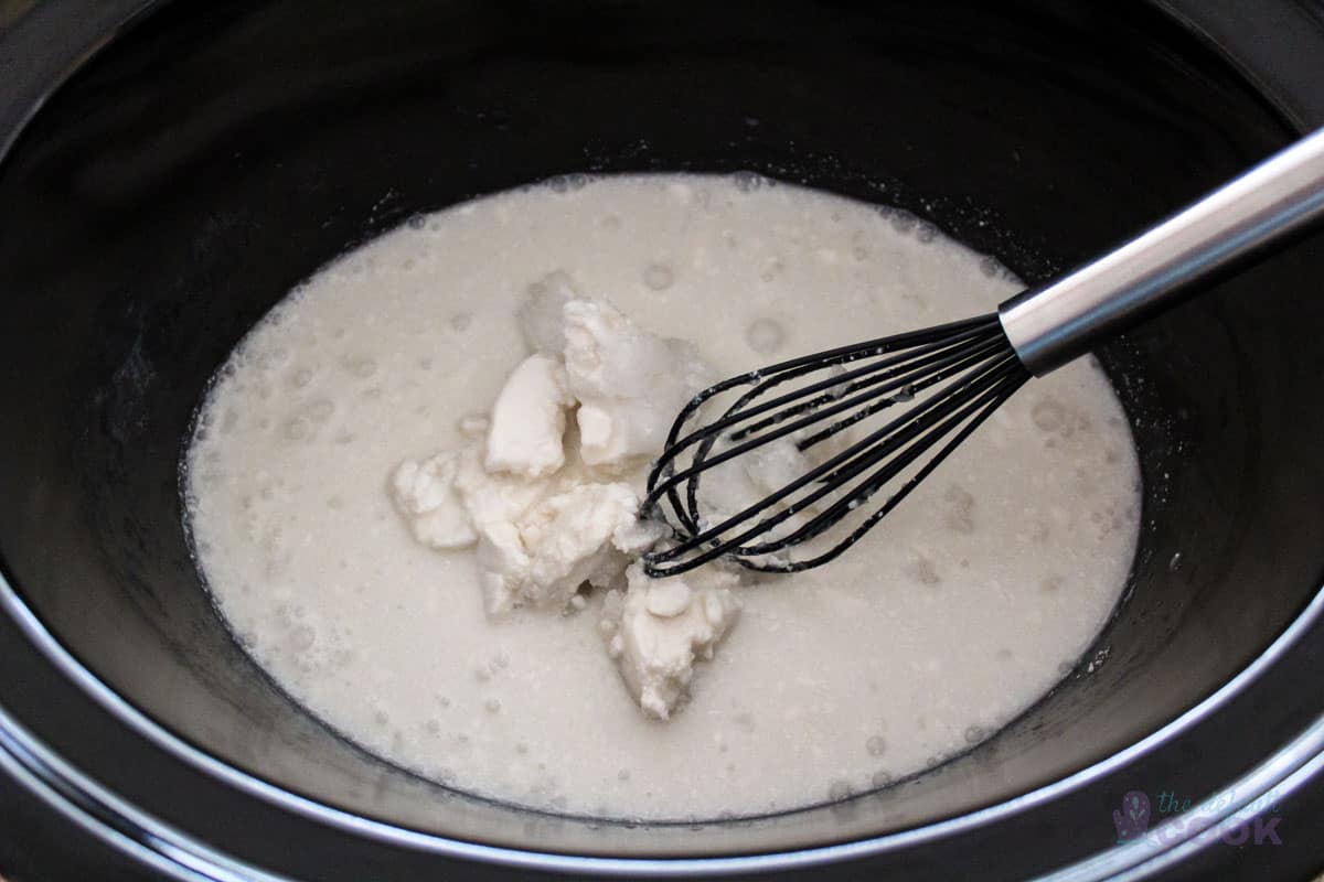 Coconut milk in crock pot before mixing with large chunks of coconut milk fat.