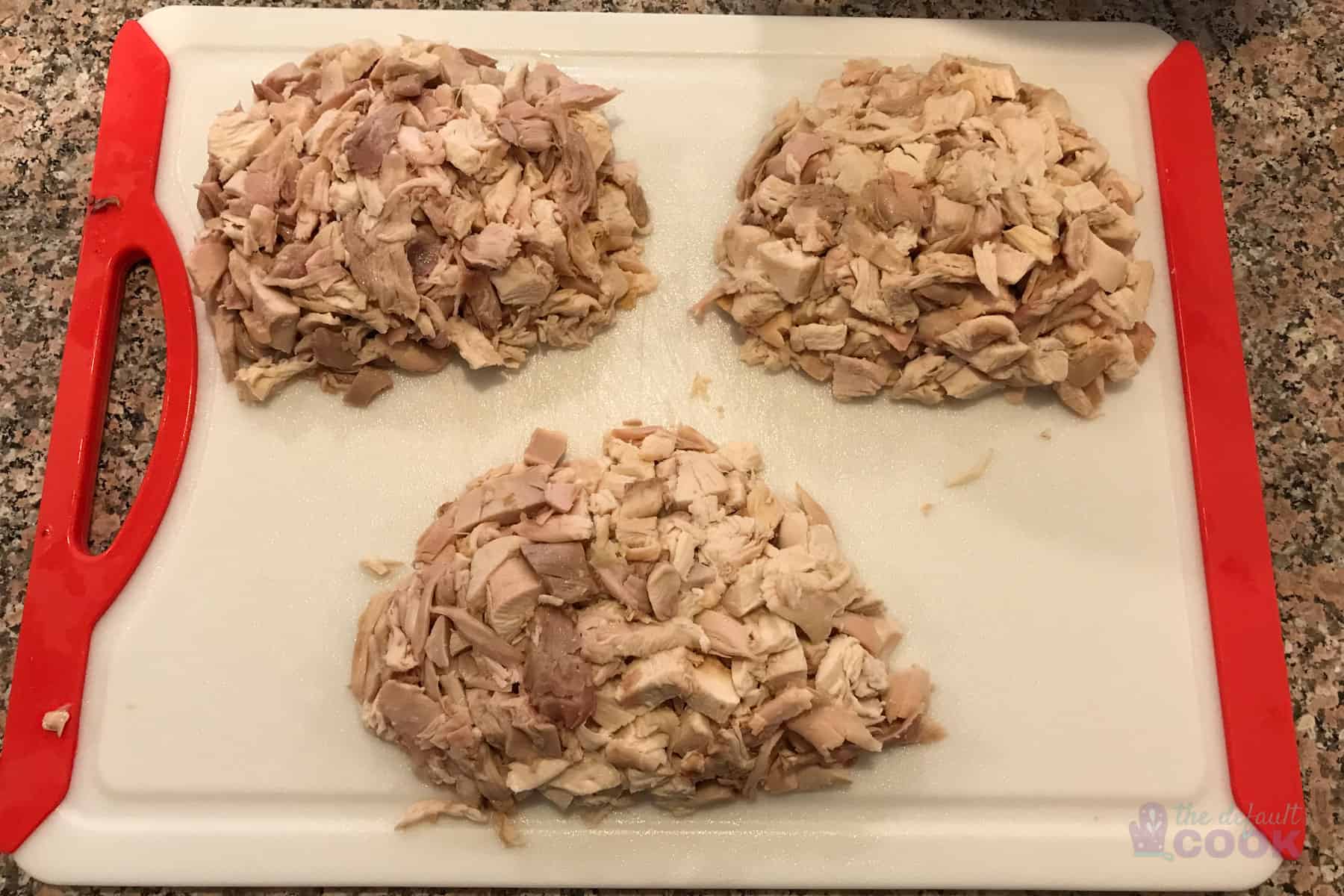 3 piles of chicken, roughly 2 cups each, sitting on a cutting board.