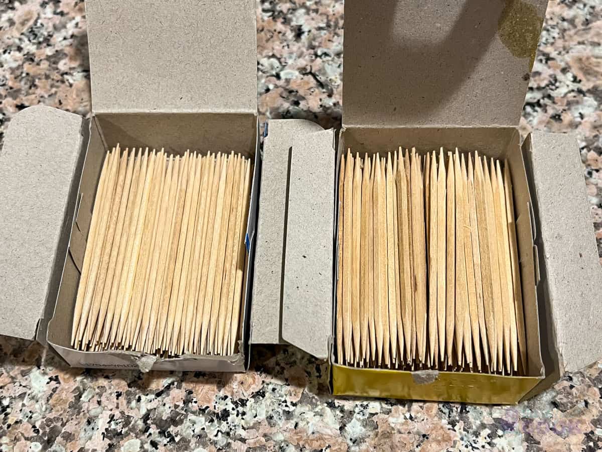 Two open boxes of wooden toothpicks on a kitchen counter.