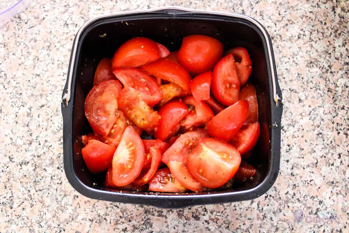 Seasoned tomatoes in a square baking dish.