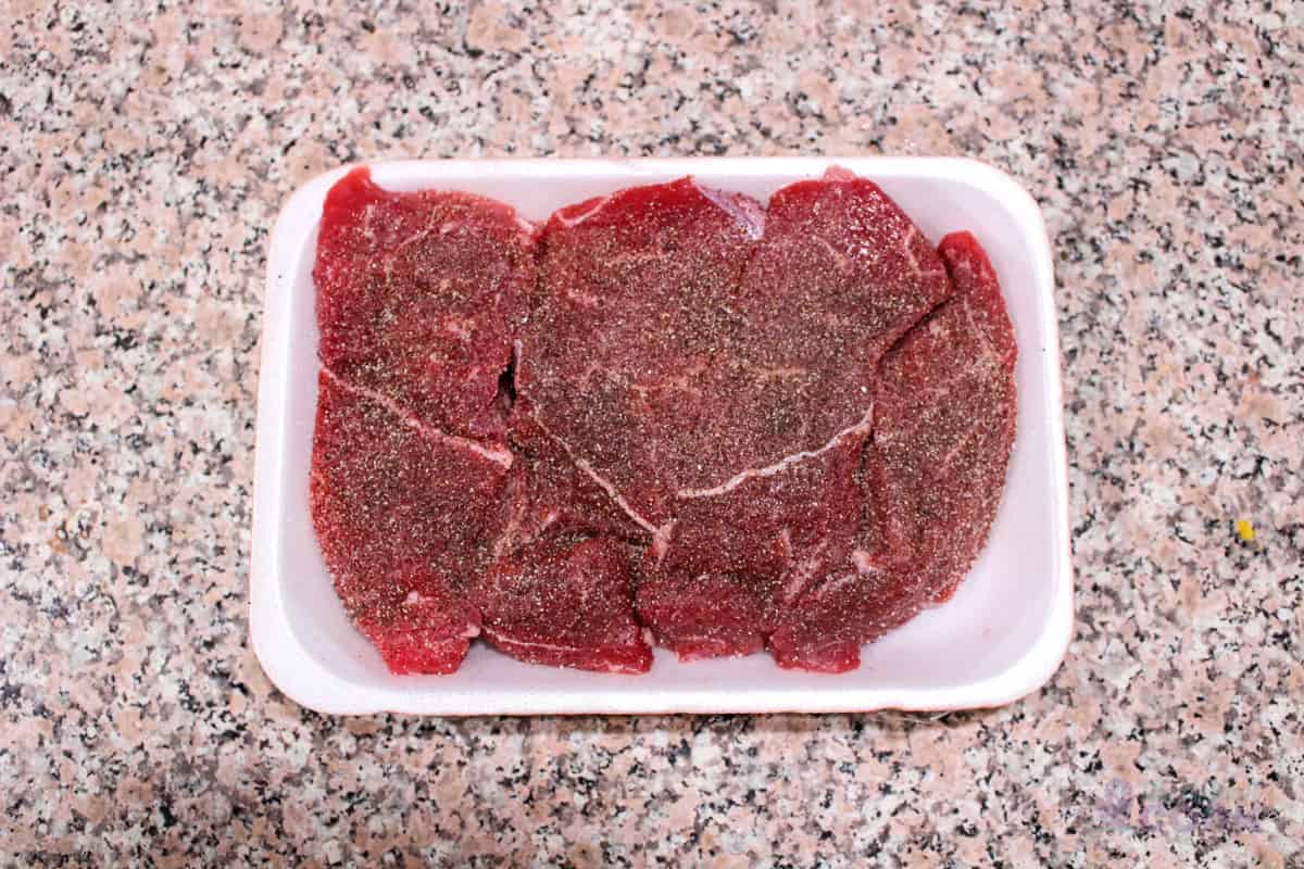 Short ribs seasoned in the package on a kitchen counter.