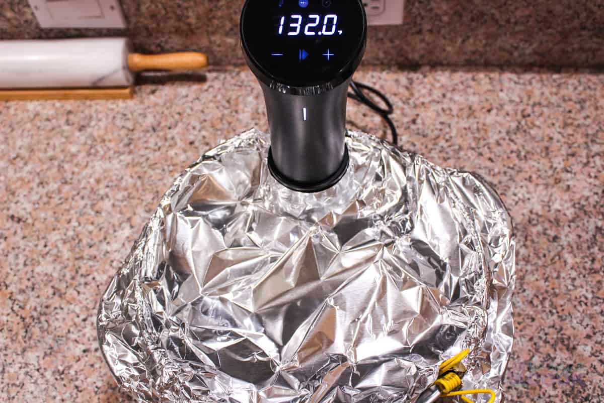 Pot covered with aluminum foil except where the sous vide machine sticks out.