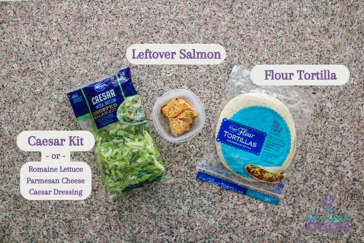 Labeled ingredients on a kitchen counter: caesar salad kit, leftover salmon, and flour tortillas.