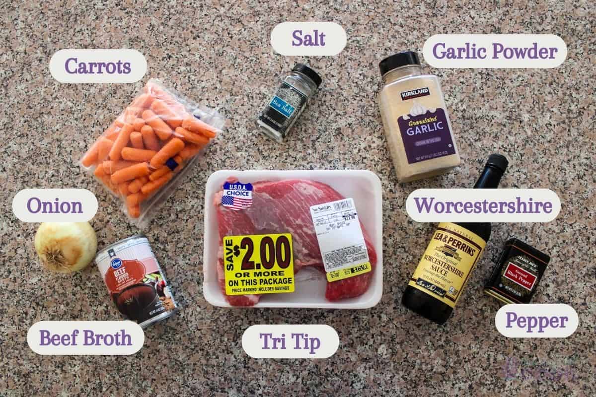 Labeled ingredients on a kitchen counter: carrots, onion, tri tip, broth, salt, pepper, garlic powder, and worcestershire sauce.