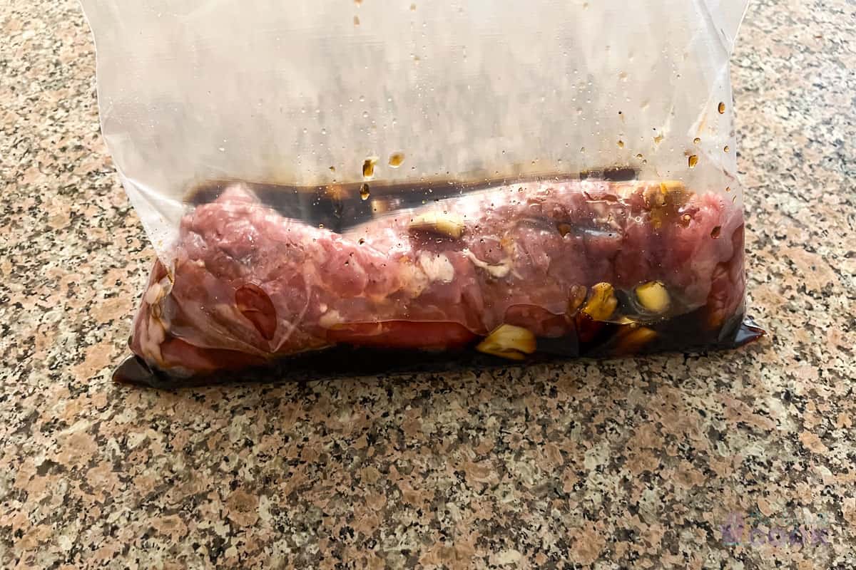 Pork marinating in a gallon ziplock bag.