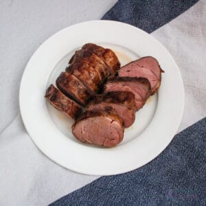 8 slices of pork tenderloin on a white plate.