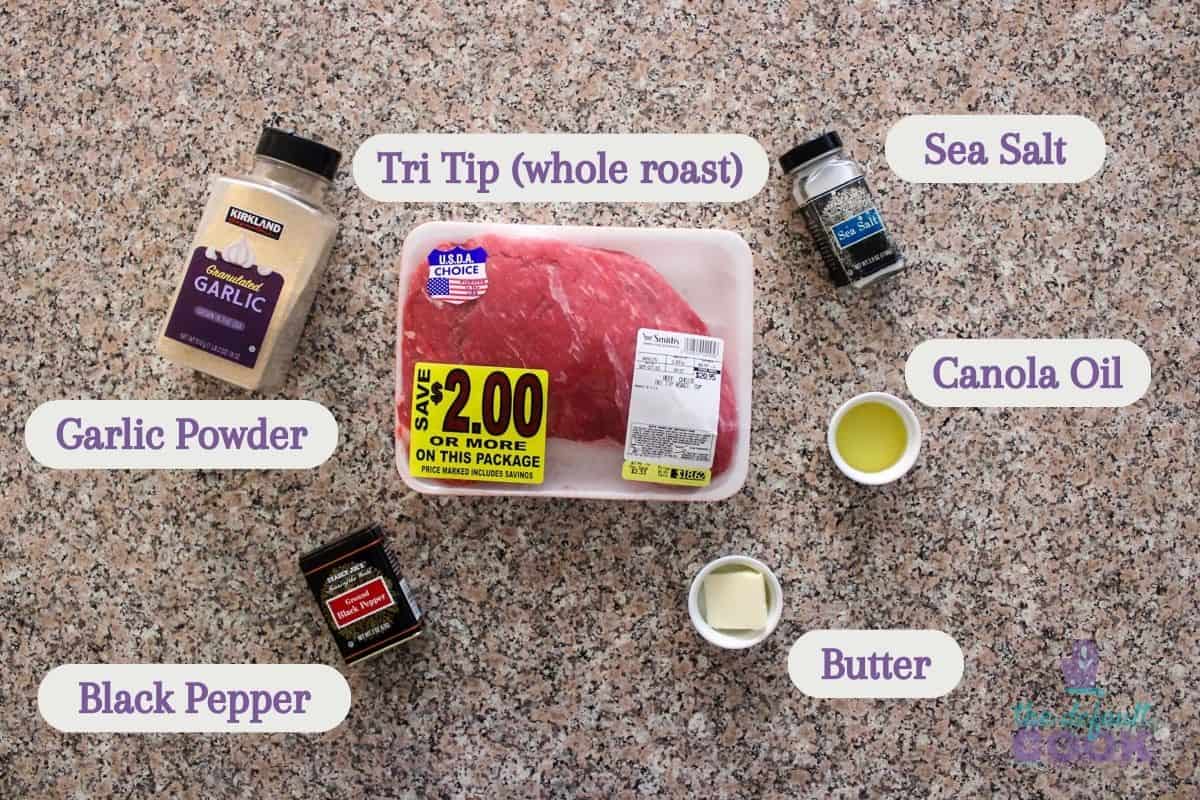 Labeled ingredients on a kitchen counter: tri tip roast, salt, oil, butter, pepper, and garlic powder.