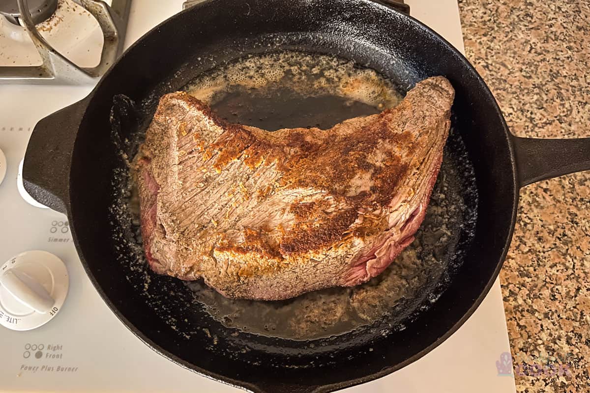 Tri tip in a skillet with the seared side up, ready to go in the oven.