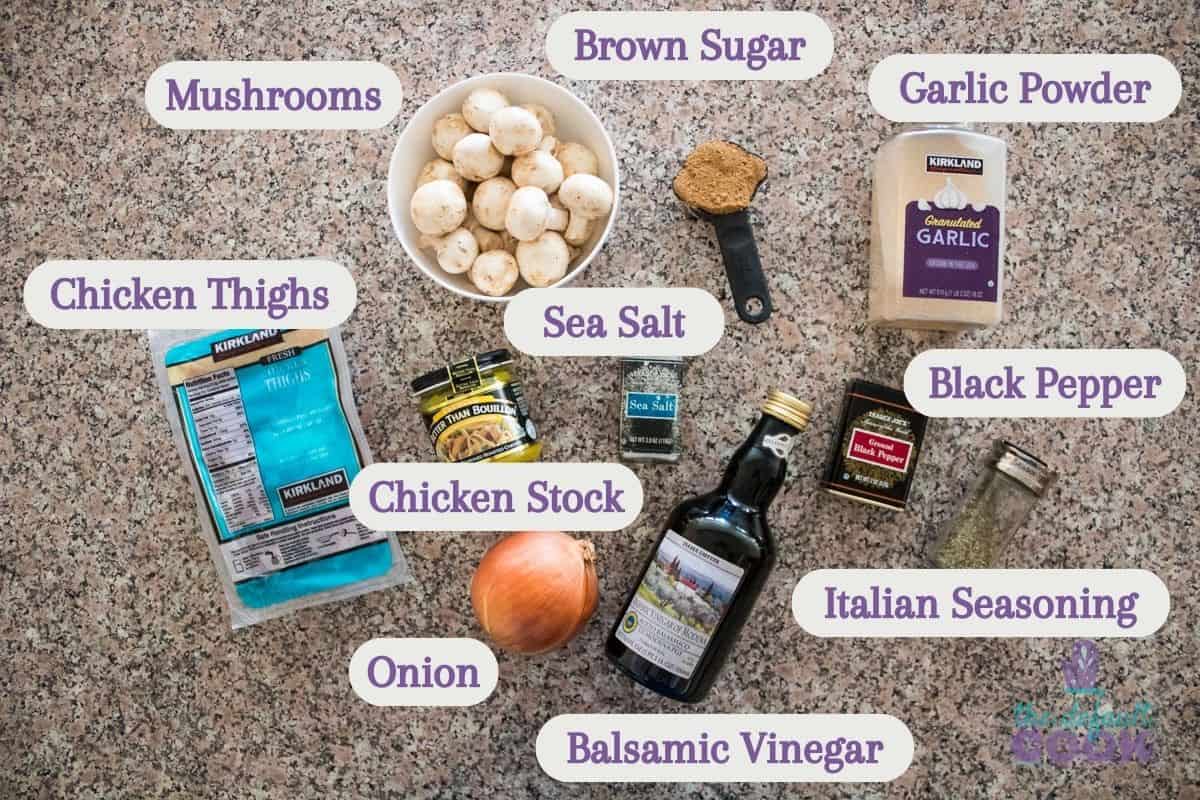 Labeled ingredients on a kitchen counter: chicken thighs, mushrooms, brown sugar, garlic powder, sea salt, black pepper, italian seasoning, chicken stock, onion, and balsamic vinegar.