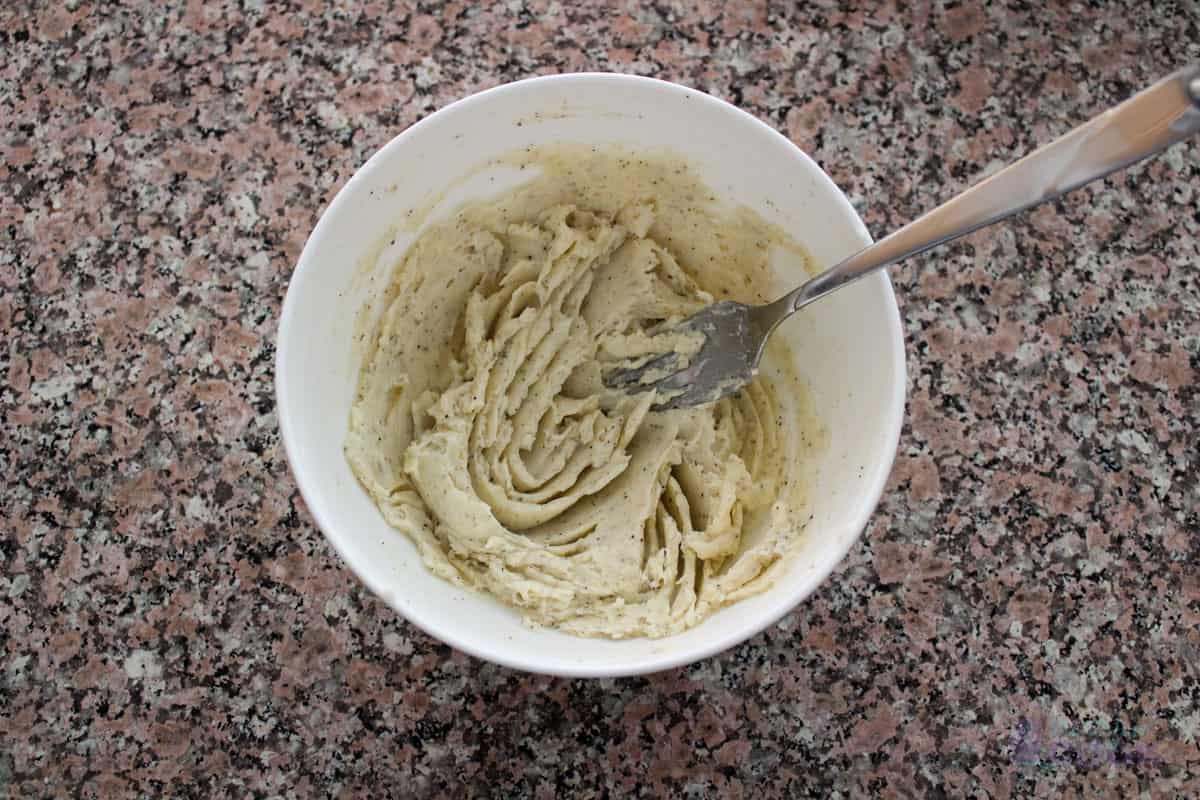 Butter mixture after fork mashing in a bowl with the fork.