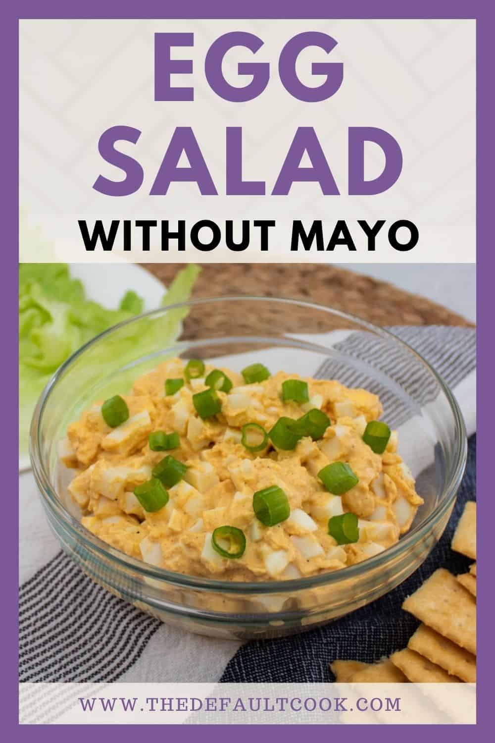 A bowl of egg salad topped with chopped green onions sits on a table next to crackers and lettuce. Text above reads Egg Salad Without Mayo. Website URL appears at the bottom.